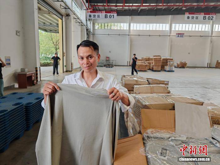 陈跃展示即将出口的衣服
