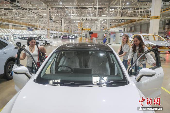 外国青年学生准备体验新能源汽车